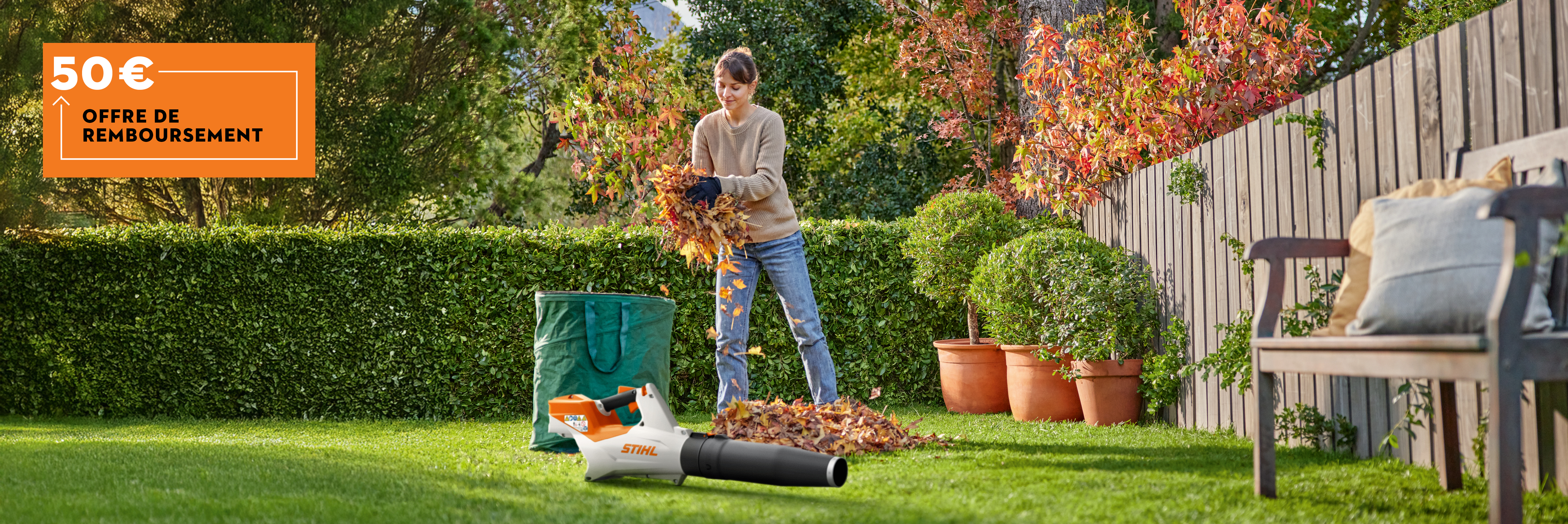 Une femme nettoie son jardin avec le souffleur à batterie STIHL